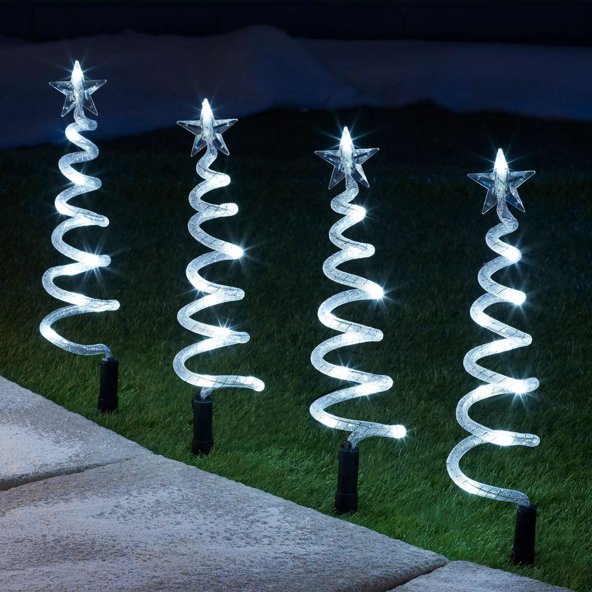 Spiral light-up trees lining a garden path