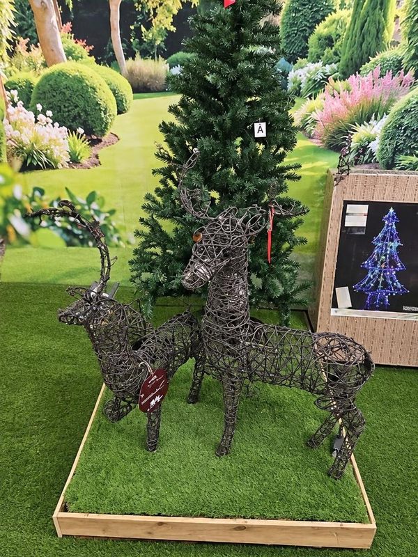 Dark rattan reindeer beside an artificial tree