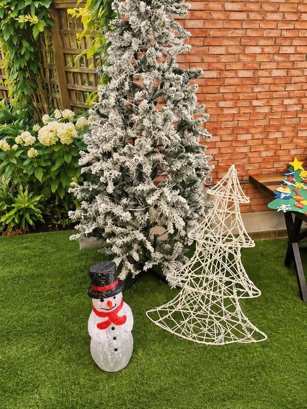 A snow-flocked tree with a light-up snowman