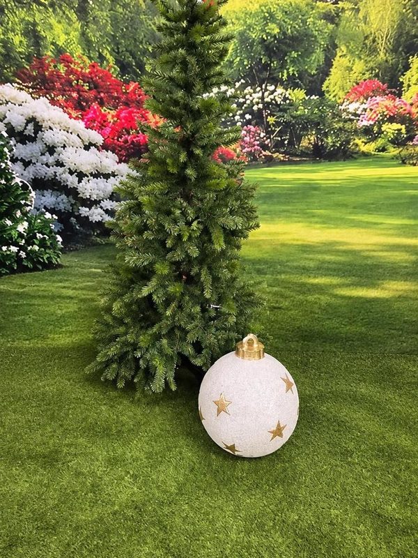 A slim artificial tree with a light-up bauble